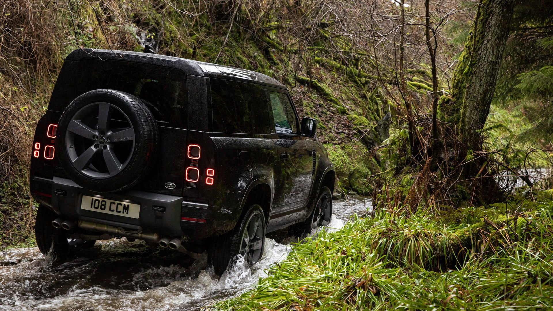 نمای عقب خودرو شاسی بلند لندرور دیفندر V8 / Land Rover Defender V8  در مسیر جنگلی