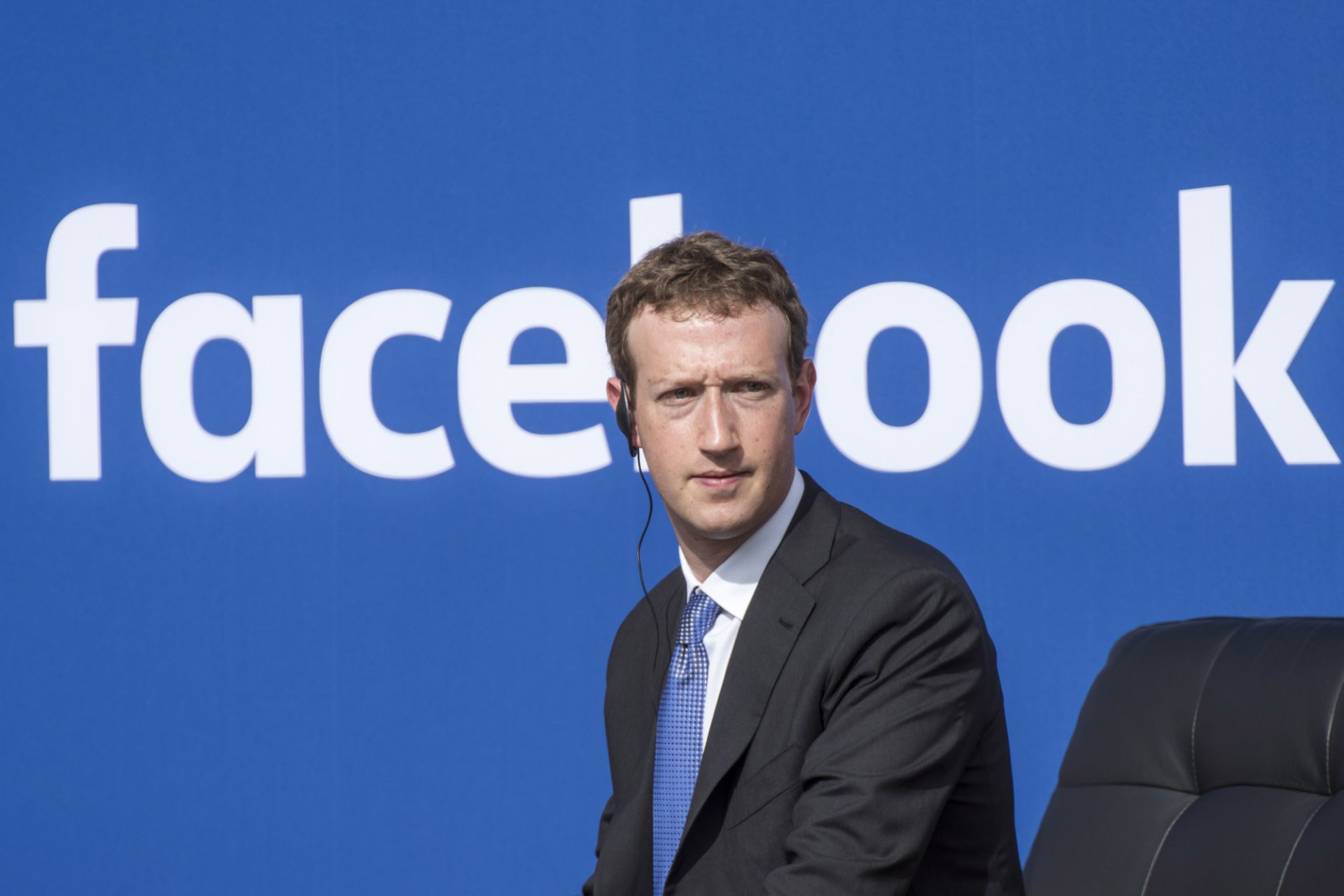 مارک زاکربرگ / Mark Zuckerberg با کت شلوار لوگو فیسبوک / Facebook در پس زمینه
