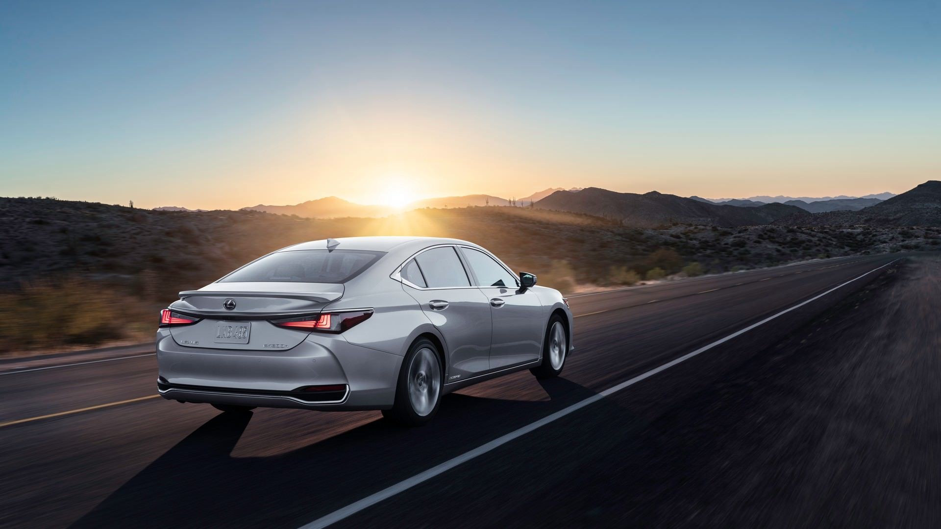 سدان لکسوس ای اس مدل 2022 / 2022 Lexus ES نقره ای رنگ با منظره غروب خورشید در جاده