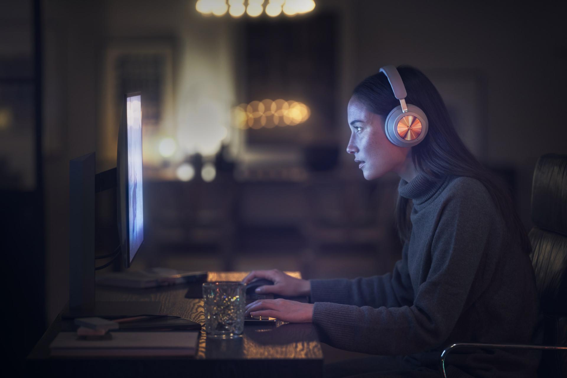 یک زن با هدفون بیوپلی پورتال بنگ اند اولافسن / B&O Beoplay Portal مشغول بازی