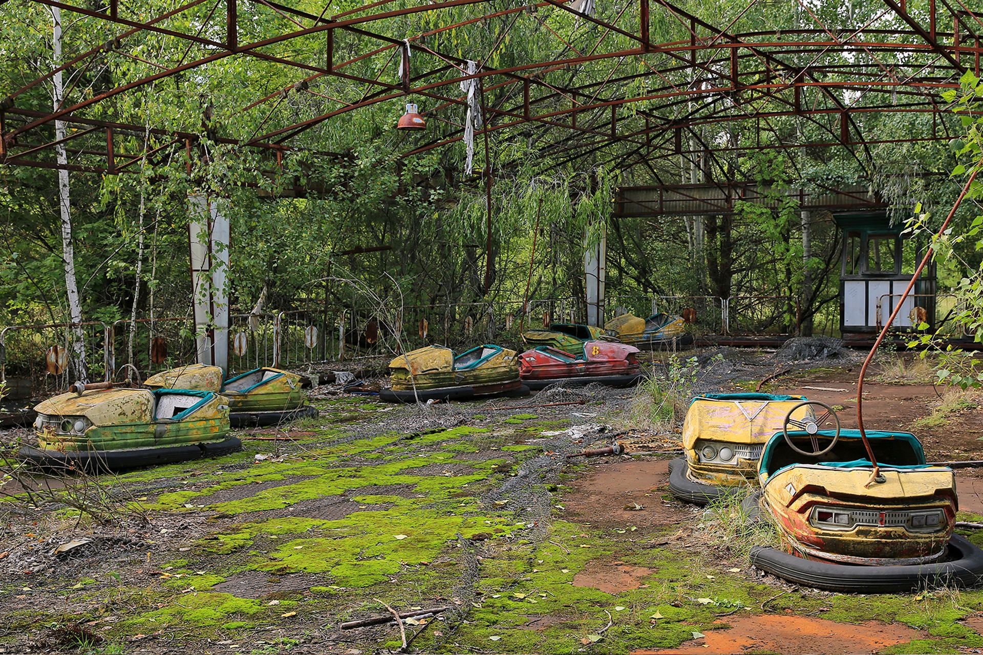 مدرسه متروکه در شهر پریپیات اوکراین نزدیک چرنوبیل با ماسک در کف زمین ماشین های برقی پارک تفریحی پریپیات در احاطه گیاه به دلیل چرنوبیل