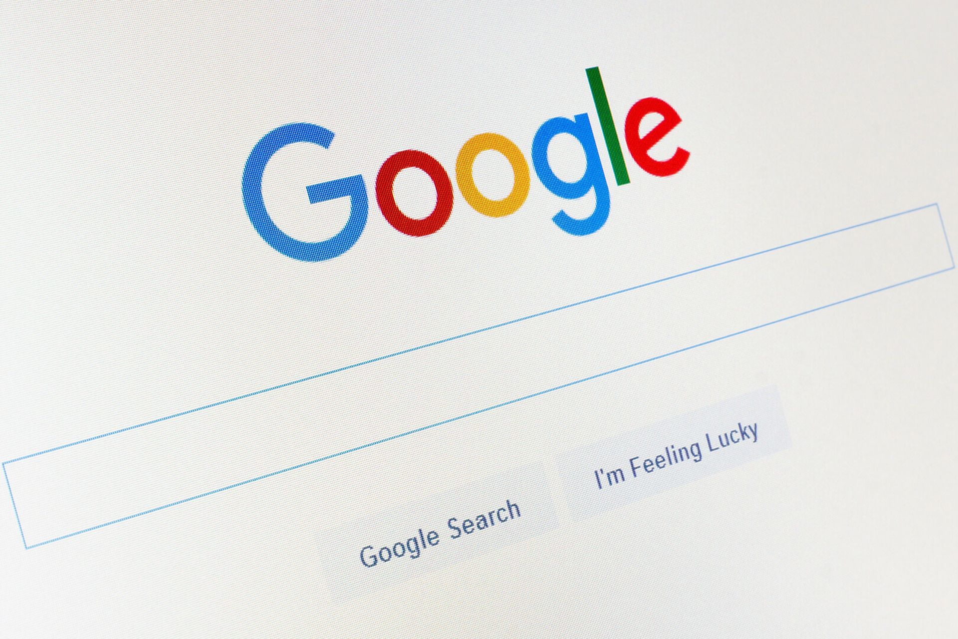 صفحه اصلی موتور جستجو گوگل / Google Search روی مانیتور از زاویه کناری