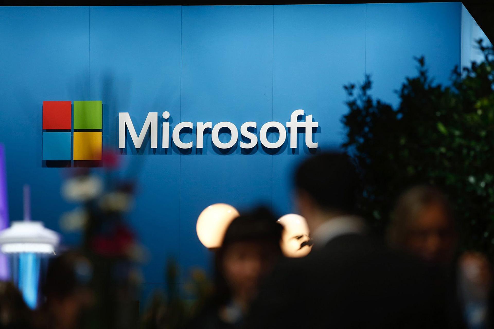 لوگو مایکروسافت / Microsoft روی دیوار آبی محیط داخلی شلوغ