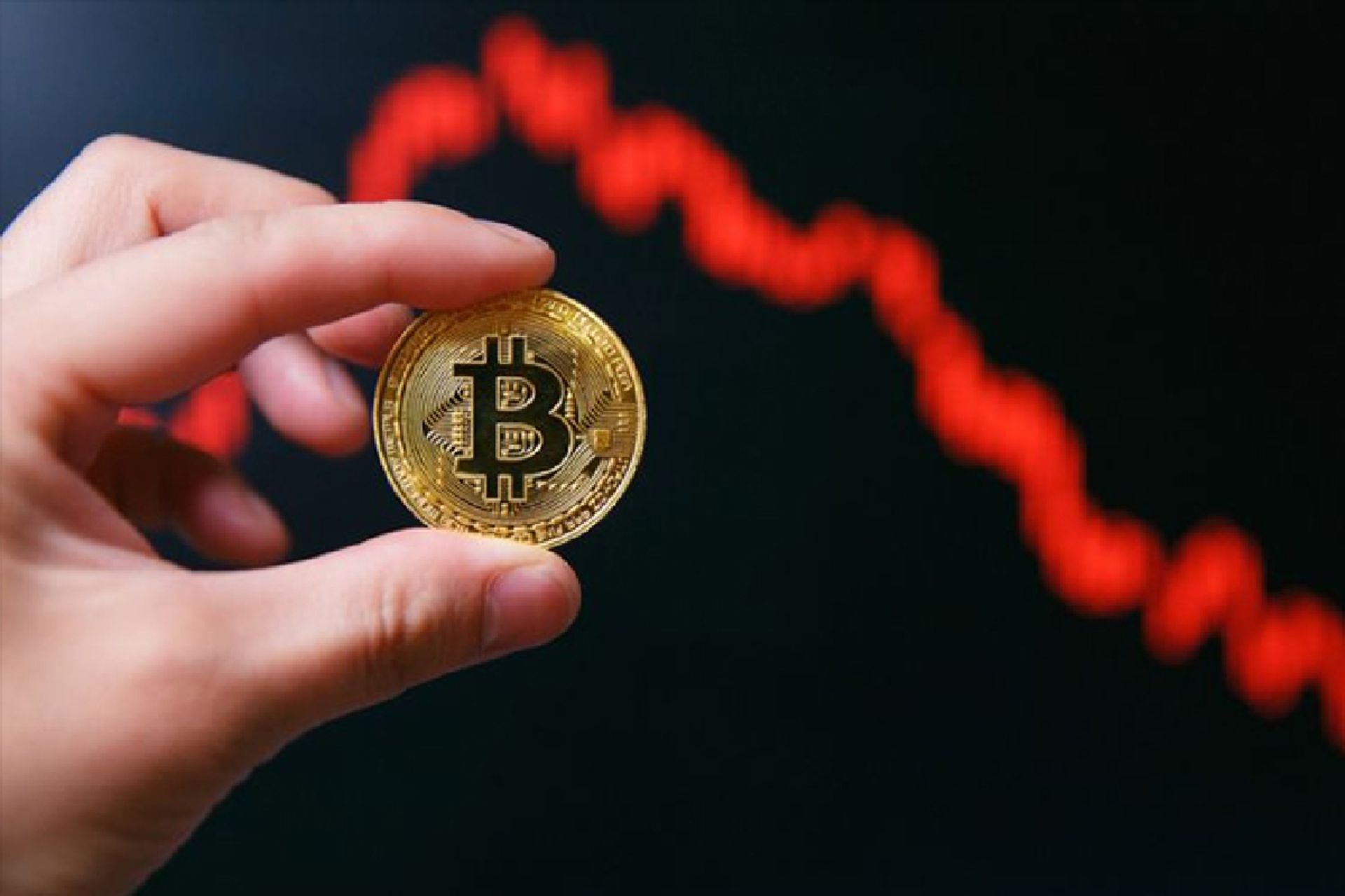 نمایی از سکه نمادین بیت کوین و چارت ریزشی