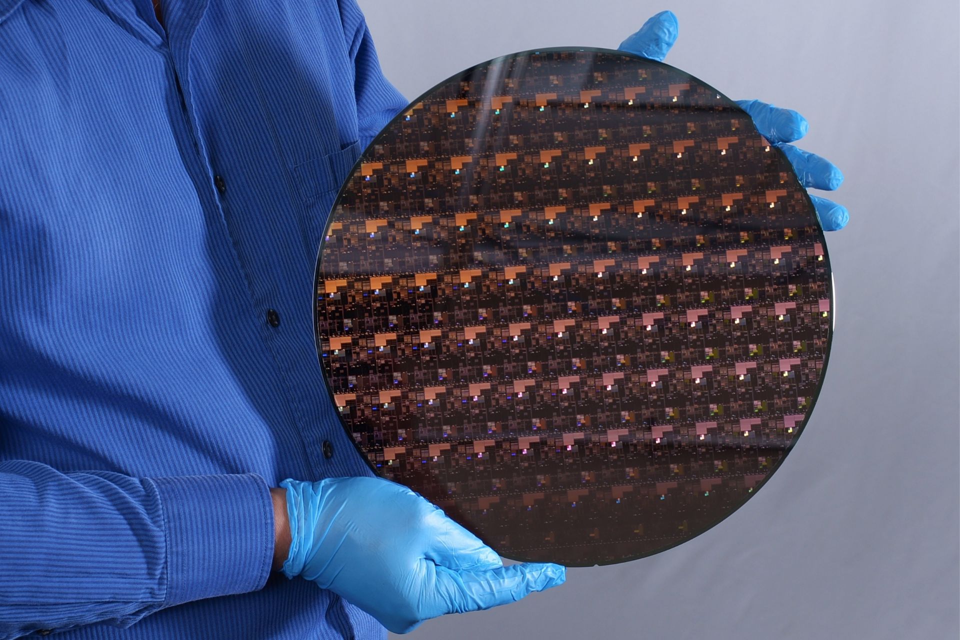 ویفر اولین پردازنده دو 2 نانومتری دنیا IBM در دست یک متخصص با لباس آبی