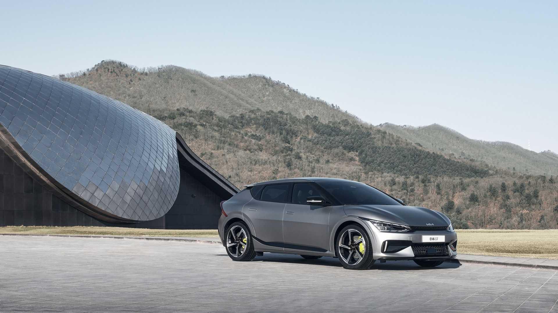 نمای جلو کراس اور برقی کیا ای وی 6 / 2022 Kia EV6 crossover خاکستری رنگ با منظره جنگل
