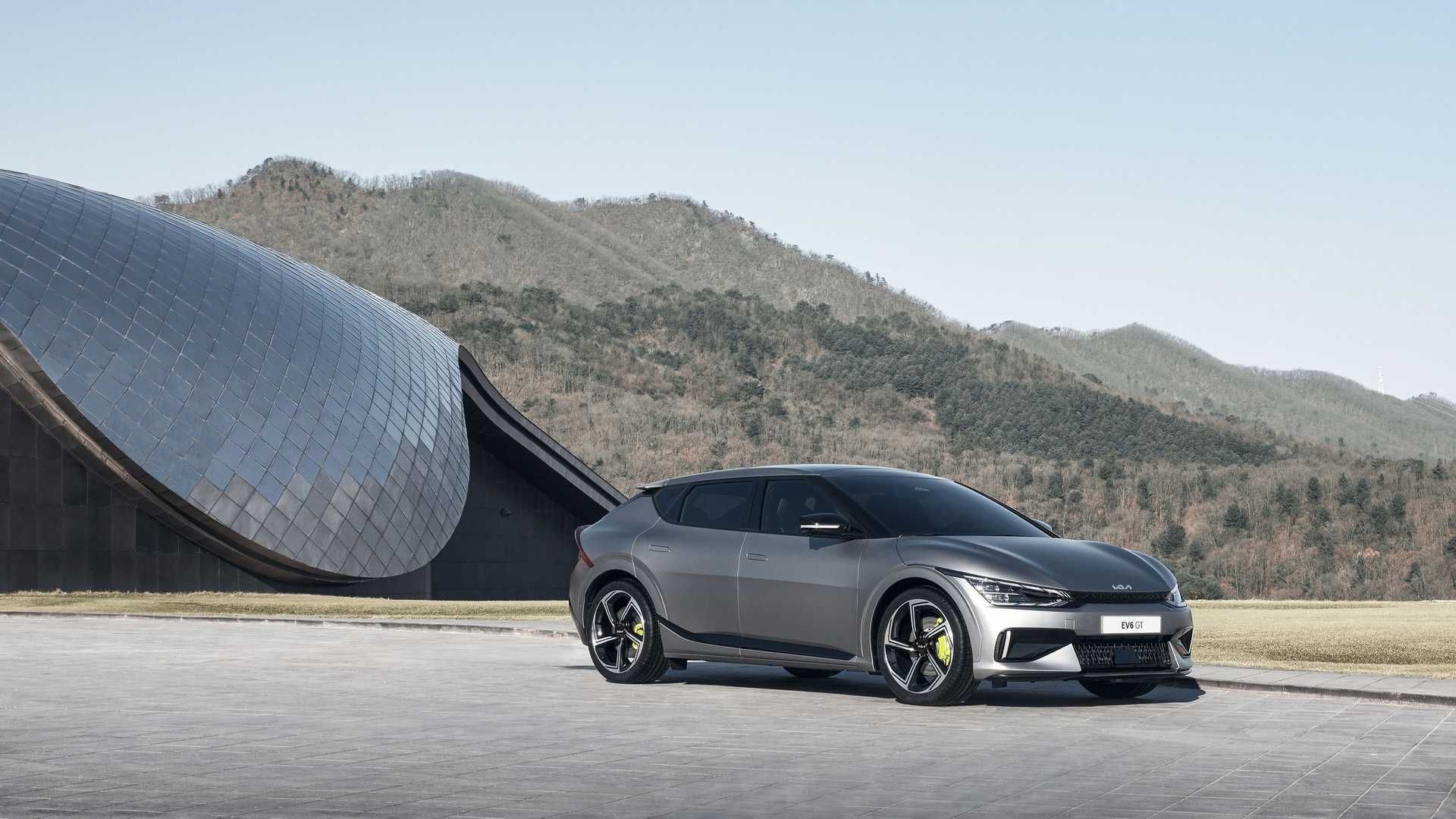 نمای جلو کراس اور برقی کیا ای وی 6 / 2022 Kia EV6 crossover خاکستری رنگ با منظره جنگل