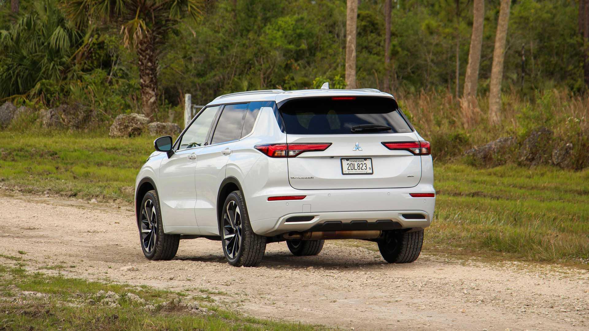 نمای عقب شاسی بلند میتسوبیشی اوتلندر / Mitsubishi Outlander سفید رنگ در جاده جنگلی
