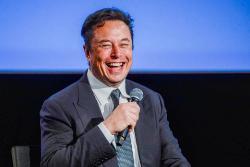 خنده ایلان ماسک Elon Musk با میکروفون و کت شلوار