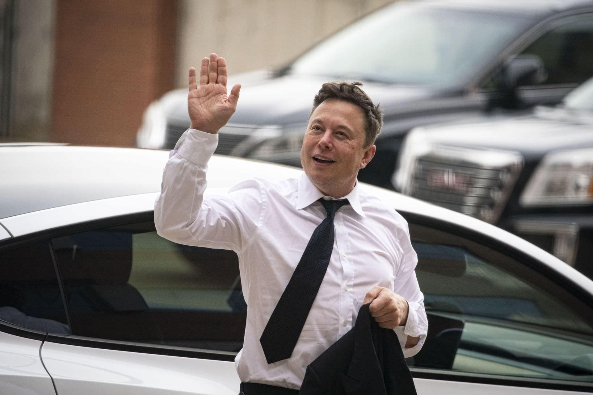 ایلان ماسک Elon Musk در حال دست تکان دادن با پیراهن سفید روز روشن