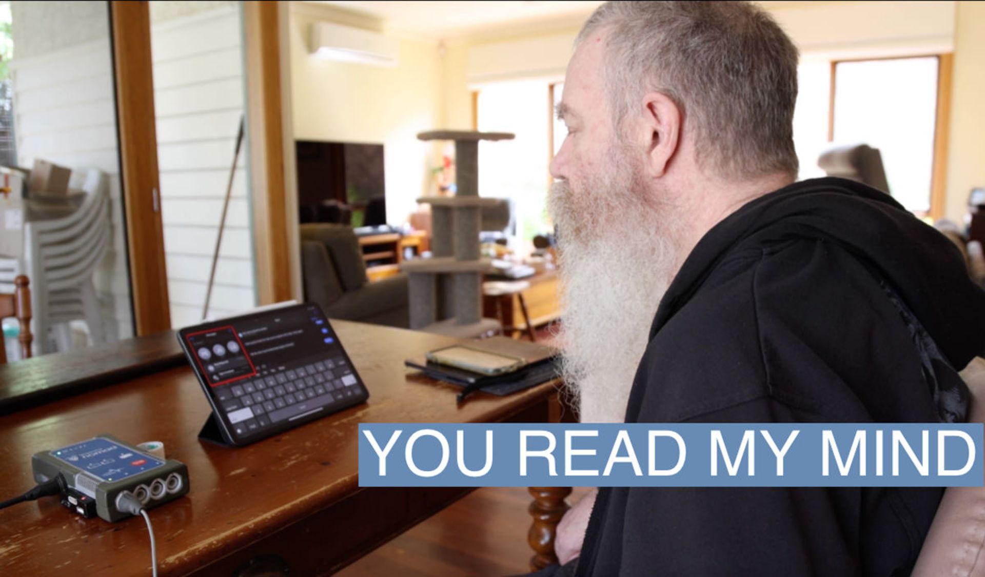 مرد ریشی در حال استفاده از آیپد در اتاق