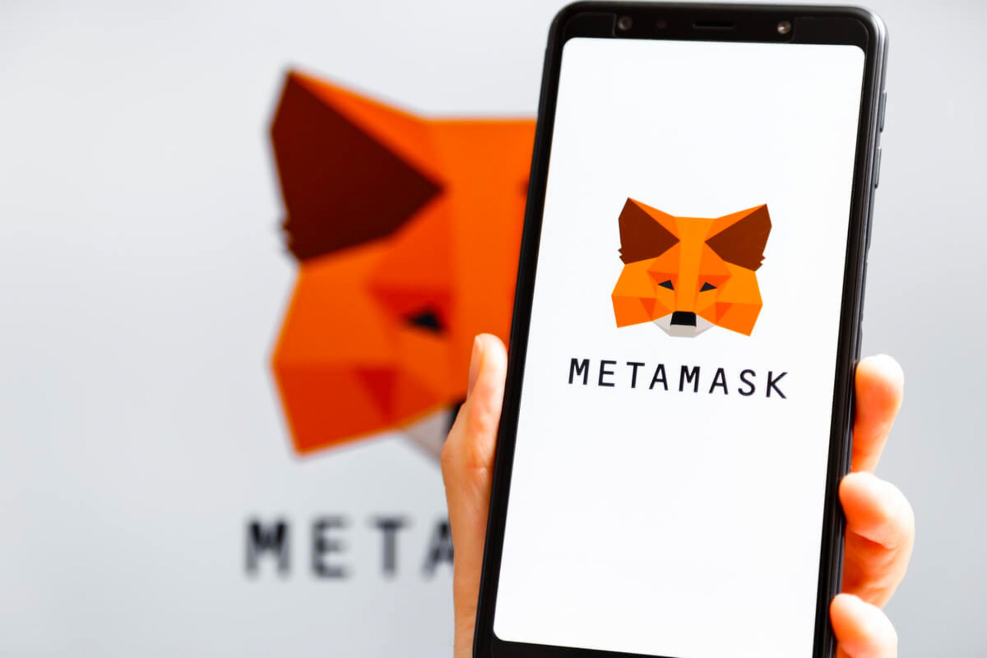 لوگو آیکون متامسک MetaMask روی موبایل در دست