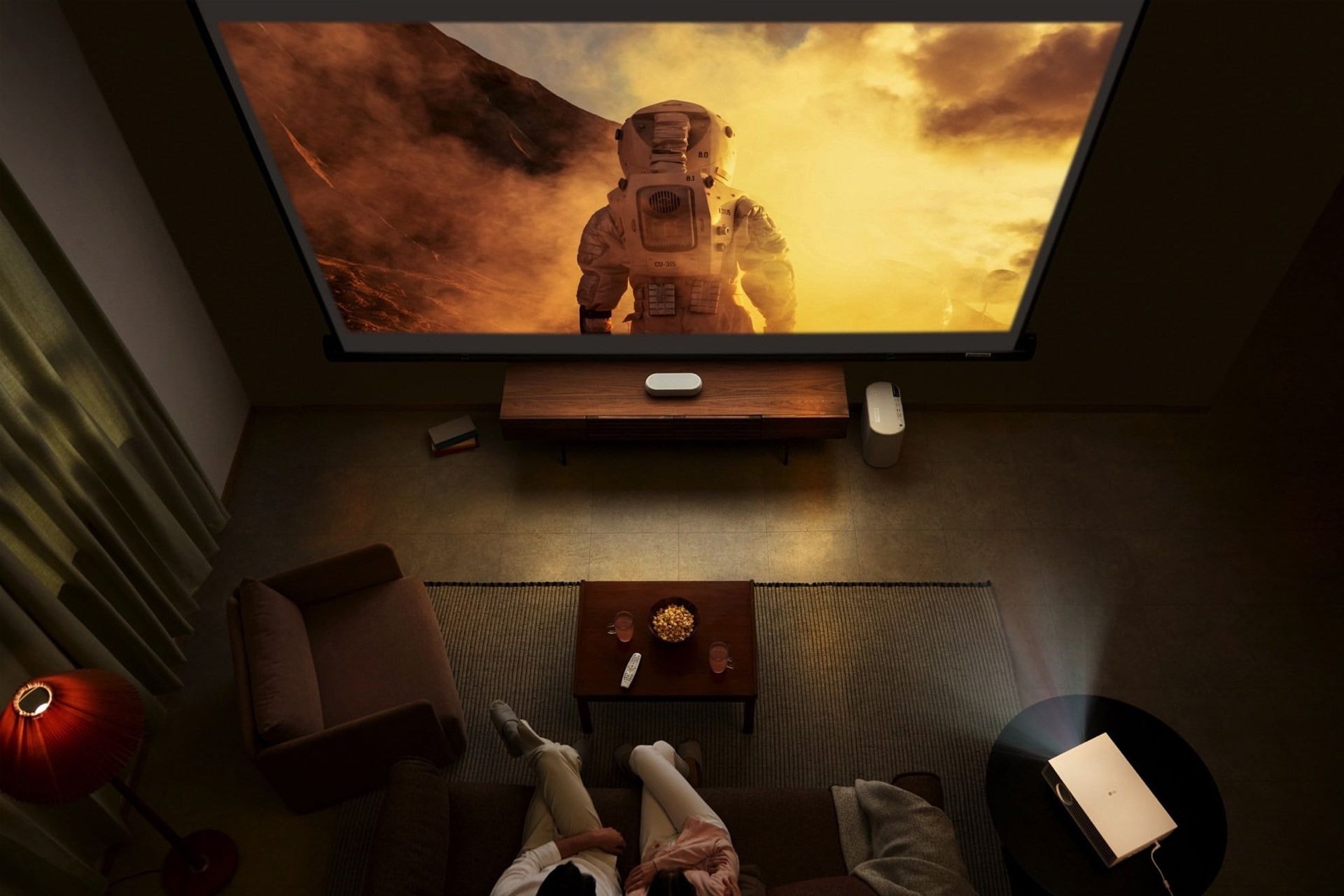 دو نفر در حال تماشا فیلم با پروژکتور 2022 ال جی HU715Q