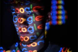 لوگو گوگل / Google روی صورت یک پسر در محیط تاریک