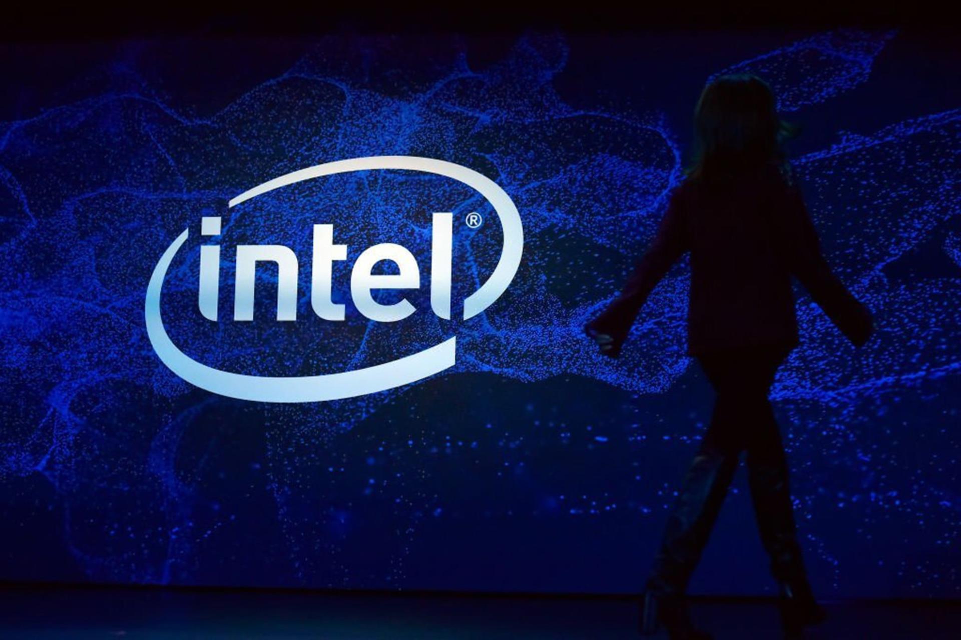 یک زن در حال قدم زدن در کنار لوگو اینتل / Intel