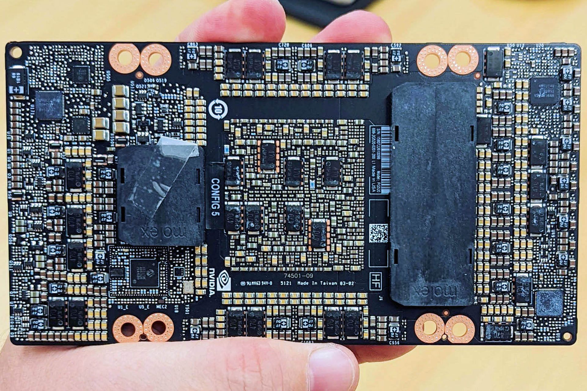 پردازنده گرافیکی Nvidia H100 SXM در دست از نمای پشت