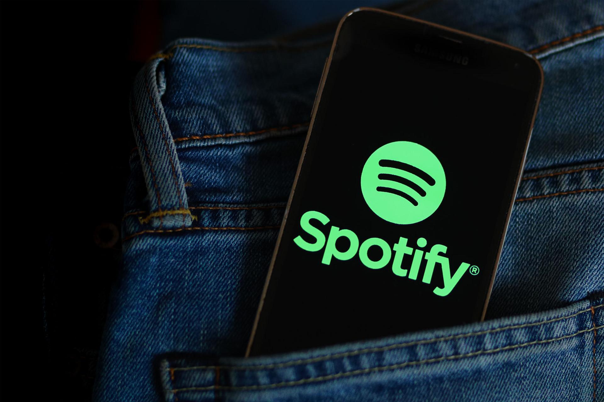 لوگو اسپاتیفای / Spotify در نمایشگر گوشی در جیب شلوار