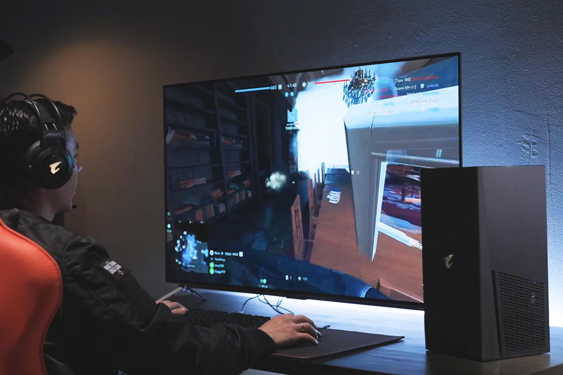 گیمر در حال بازی با کامپیوتر گیمینگ AORUS Model S 2022 و مانیتور