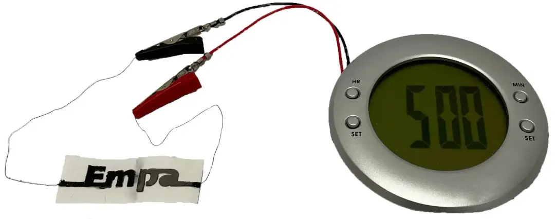 باتری کاغذی در حال تأمین انرژی ساعت زنگ دار LCD
