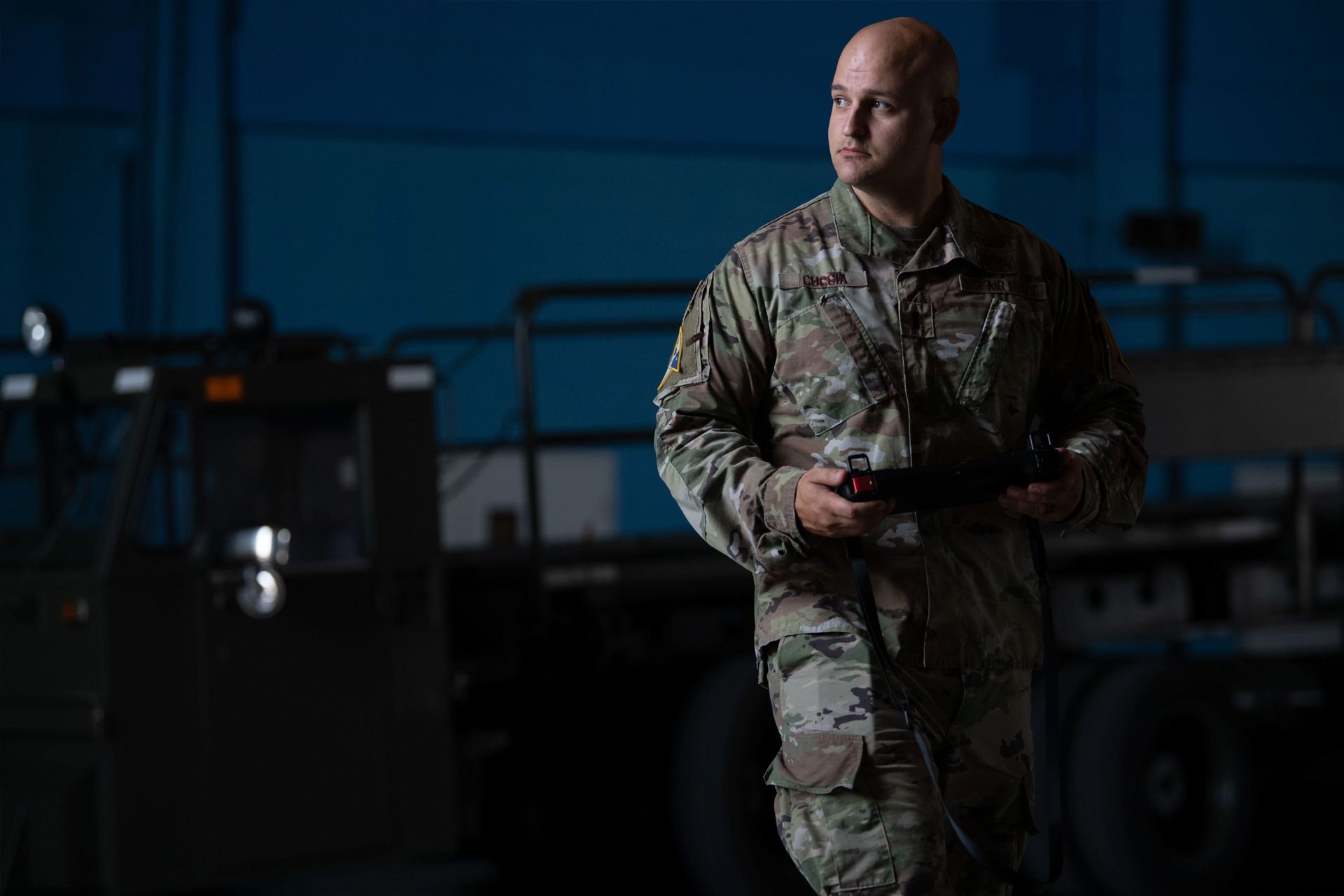 مرد کچل با لباس نظامی در شب اپراتور سگ رباتیک ویژن 60 آمریکا