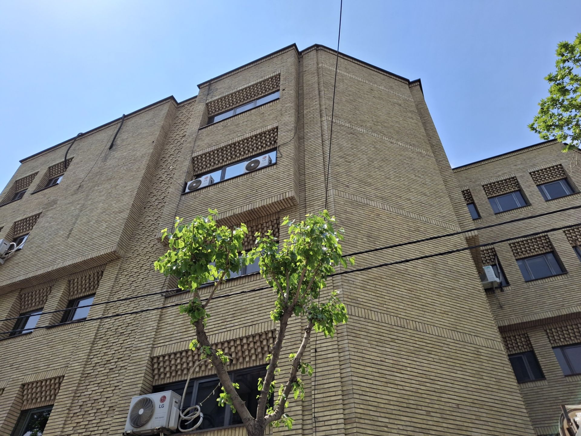 نمایی از یک ساختمان آجری با پس زمینه آسمان آبی در نور روز با دوربین گلکسی A35