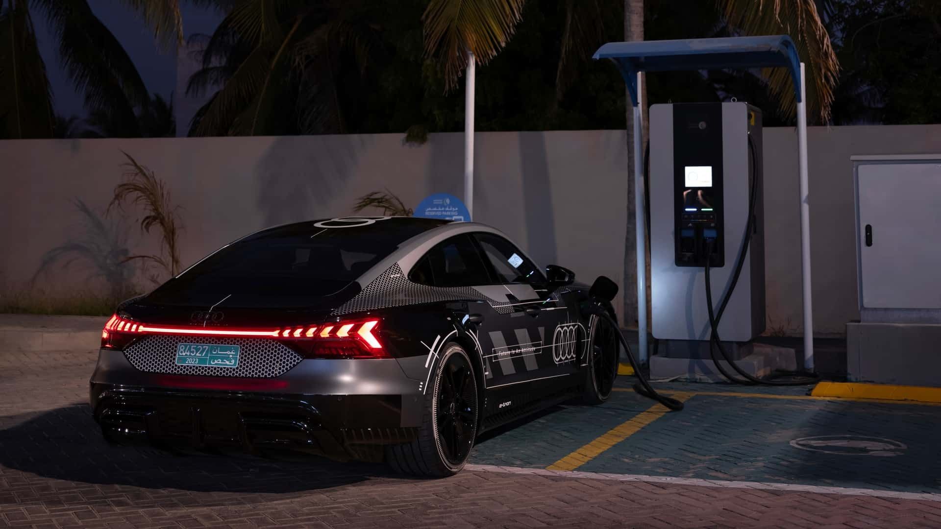 نمای سه‌چهارم عقب خودرو آئودی E-Tron GT Performance درحال شارژ