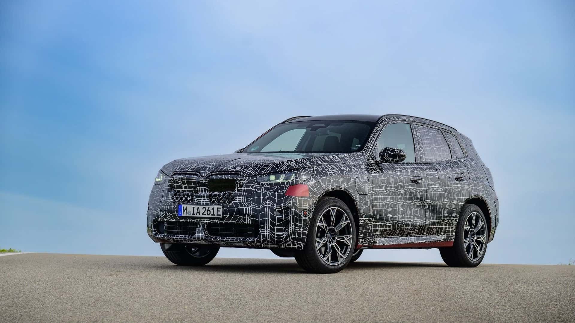 نمای سه‌چهارم جلو نمونه‌ی آزمایشی و استتارشده‌ی خودرو BMW X3 2025 