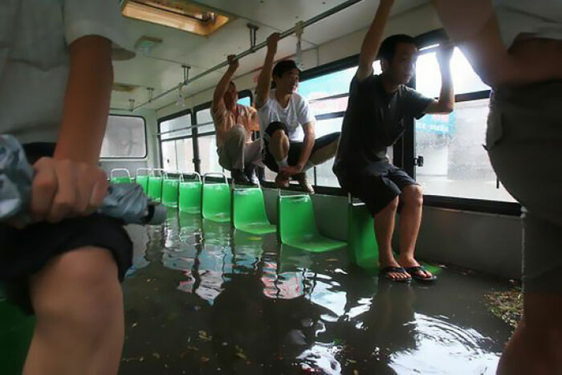 مسافران آویزان از سقف اتوبوس آب‌ گرفته