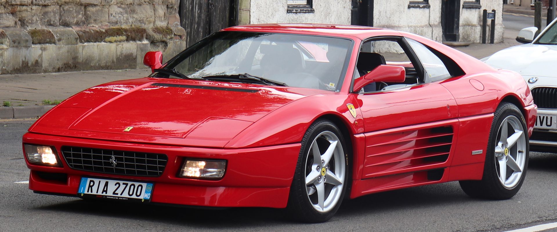 خودروی Ferrari 348 به رنگ قرمز از نمای کناری