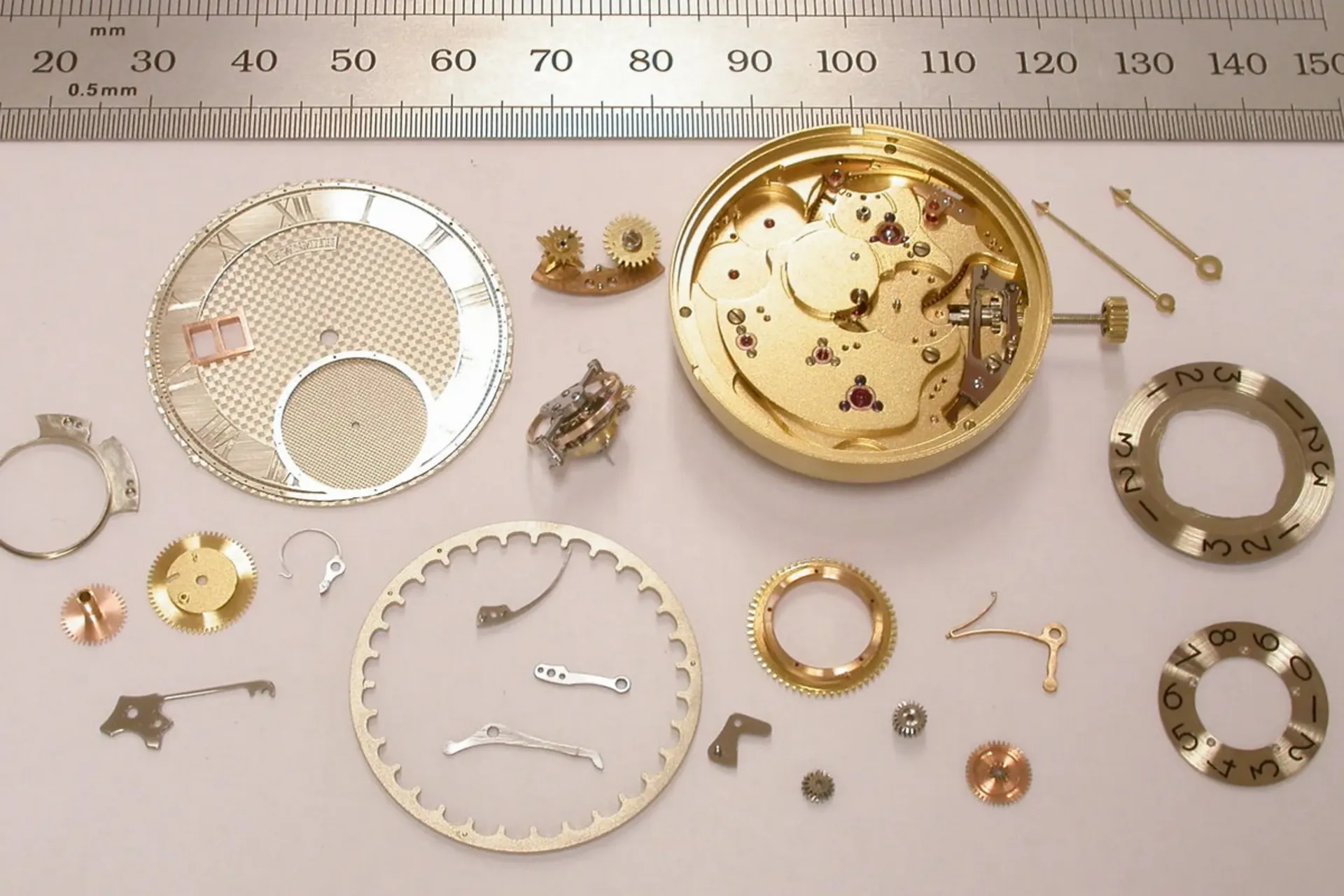 اجزای سک ساعت قدیمی باز شده روی میز