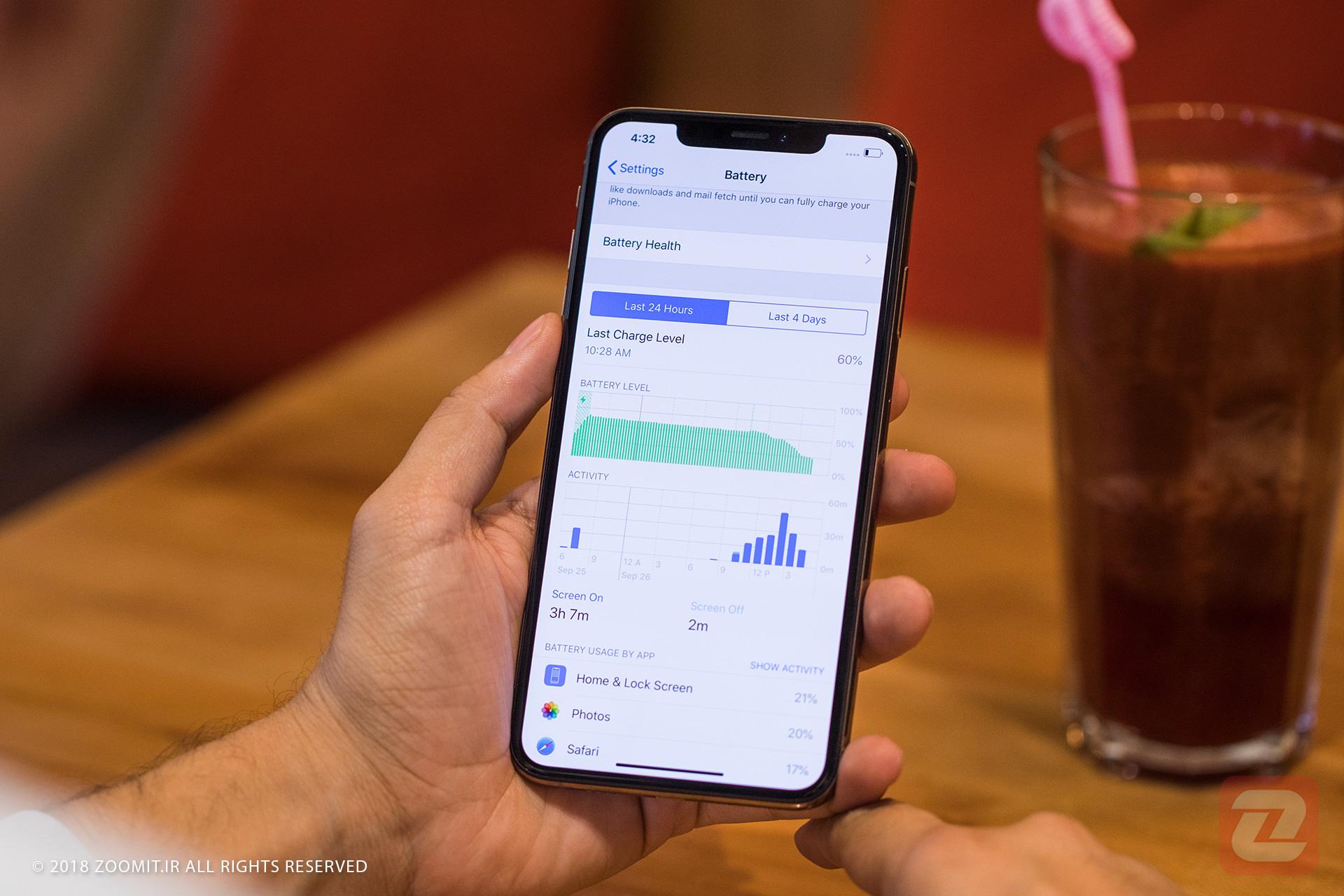 صفحه تنظیمات باتری در آیفون ۱۰ اس مکس / iPhone XS Max اپل دست چپ میز چوبی نوشیدنی با نی