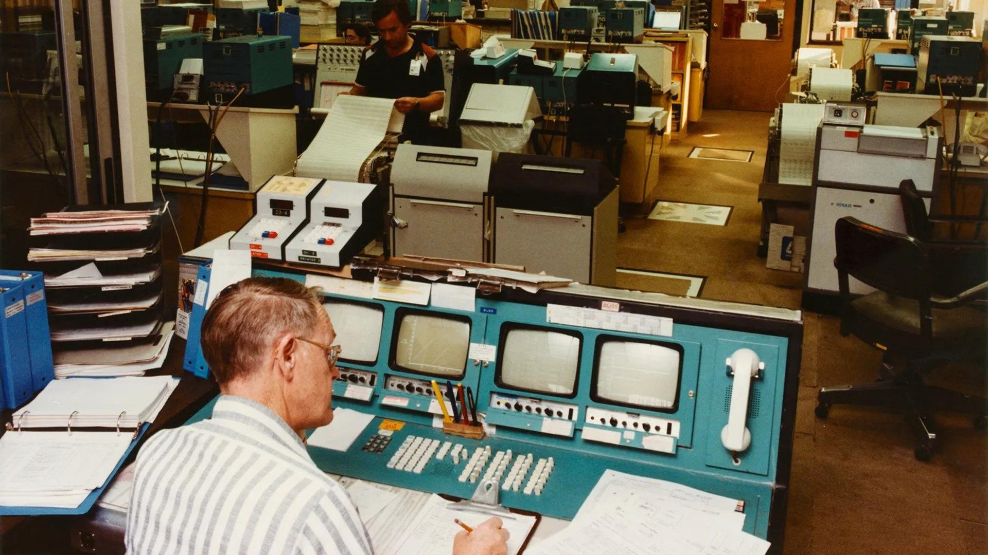 مردی در حال کار با کامپیوترهای قدیمی