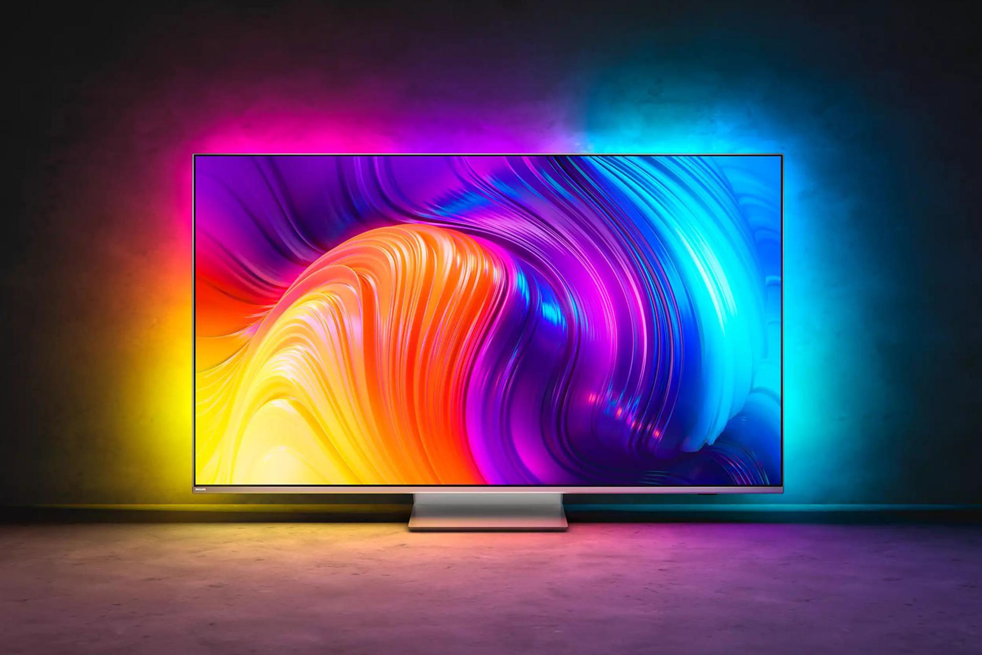 تلویزیون فیلیپس Philips PUS8887 سری 8800  نمای جلو با نورپردازی Ambilight در اتاق تاریک