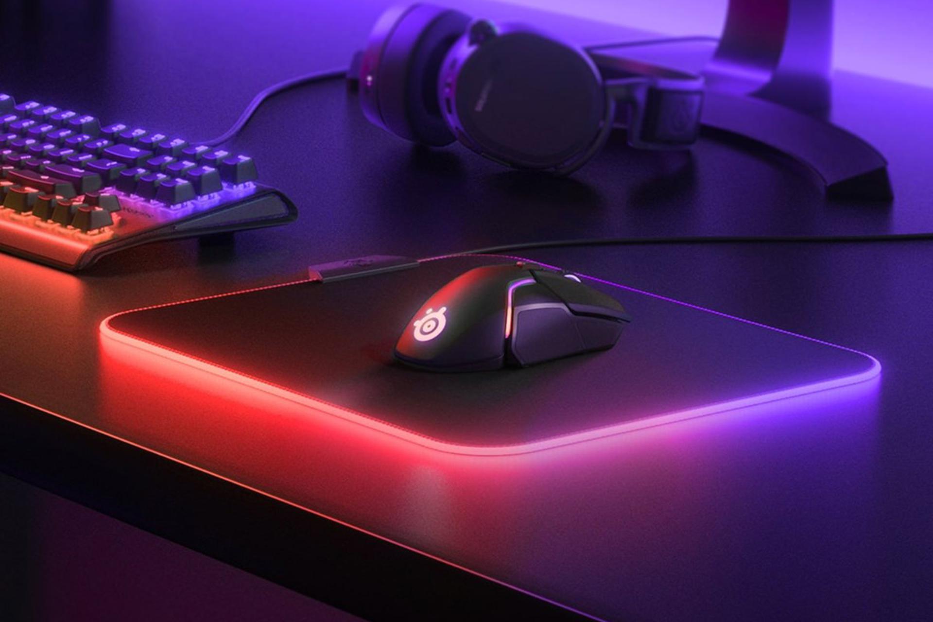 نورپردازی ماوس پد استیل سریز SteelSeries QcK Prism Medium روی میز به همراه ماوس
