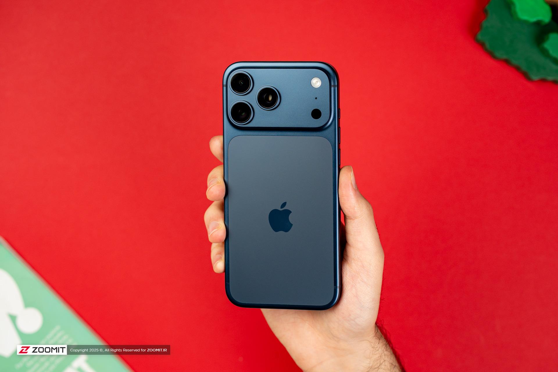 مدل آبی آیفون ۱۷ پرو مکس / iPhone 17 Pro Max در دست پس زمینه قرمز