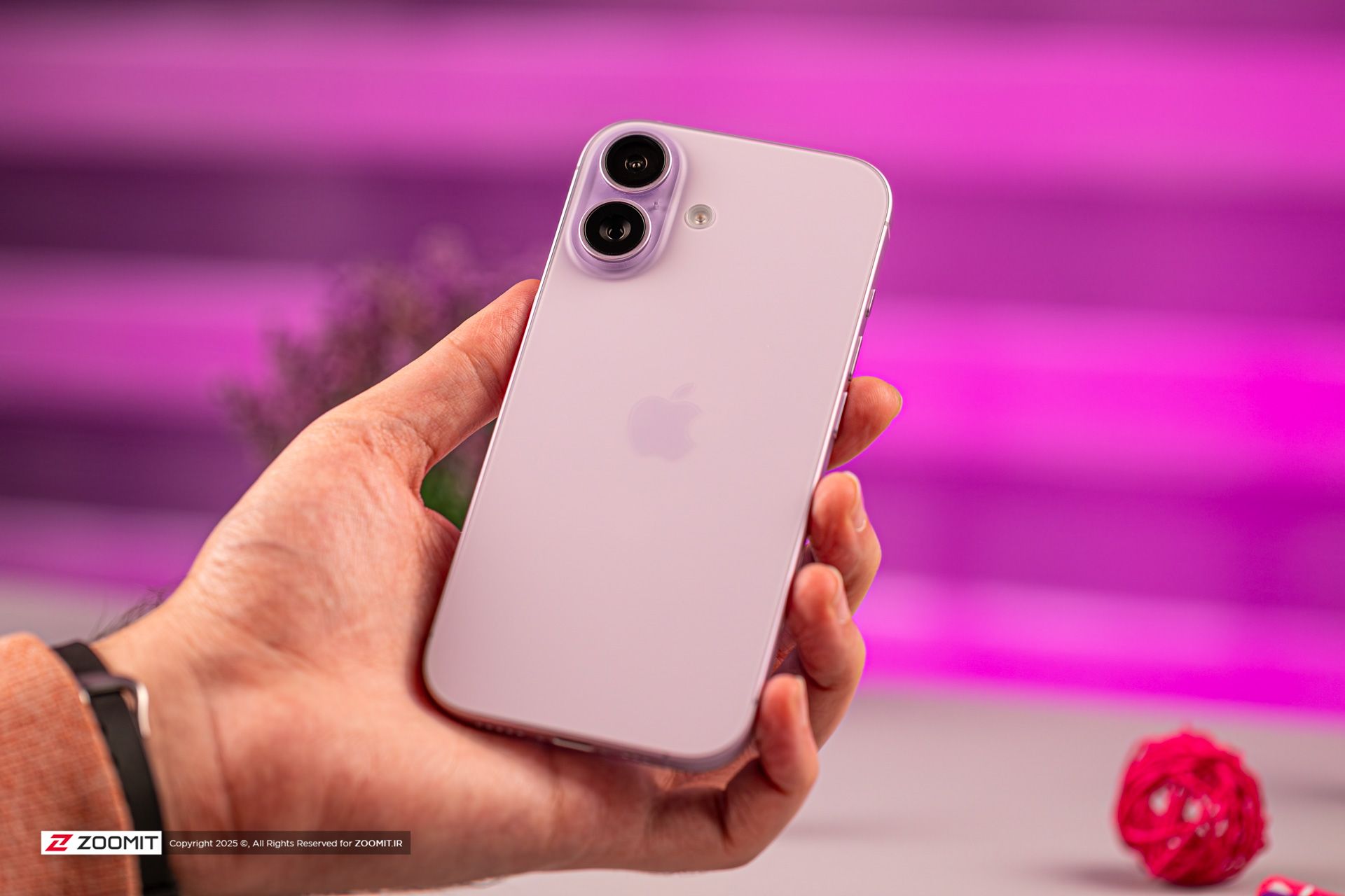 نمای نزدیک پشت آیفون بنفش در دست