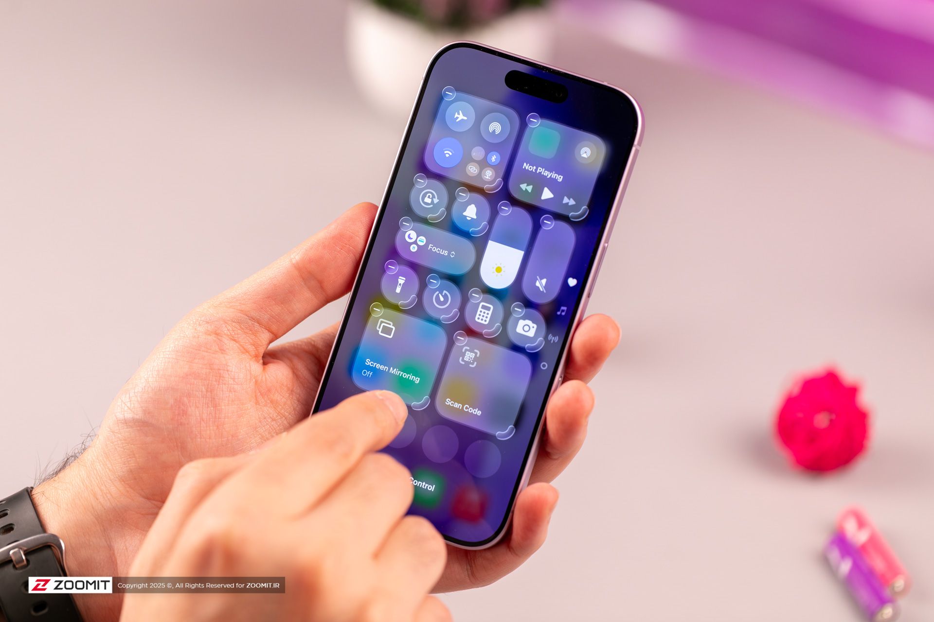 کنترل سنتر iOS روی آیفون بنفش در دست 