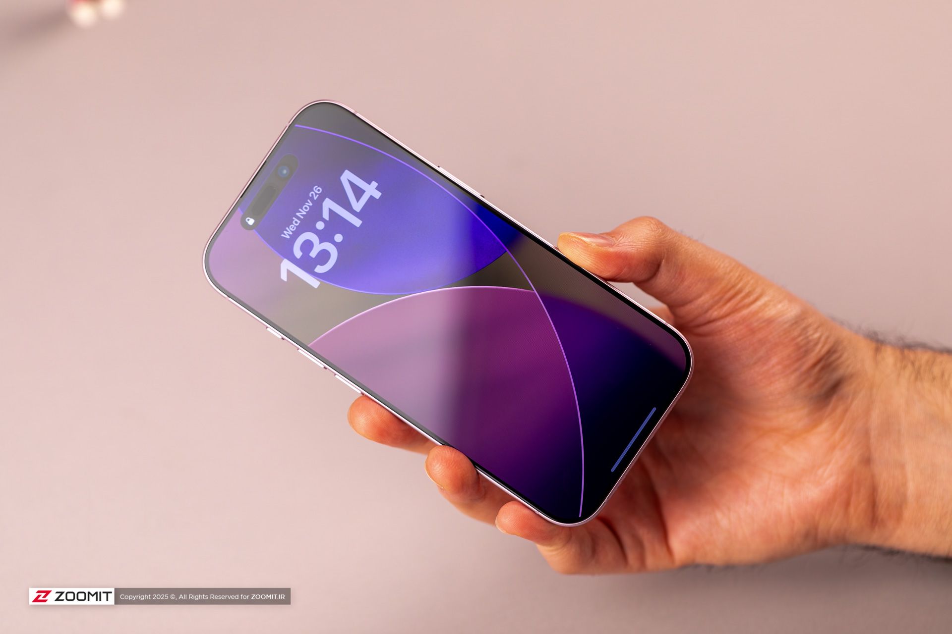 آیفون بنفش در دست کاربر با صفحه قفل بنفش روشن.