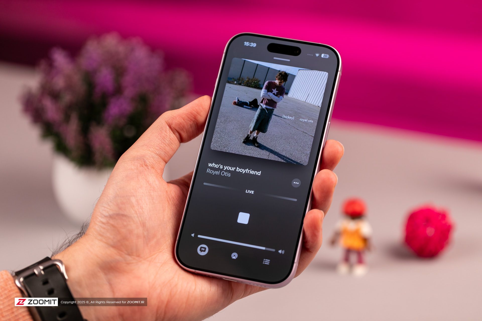 آیفون بنفش در حال پخش موسیقی در دست 