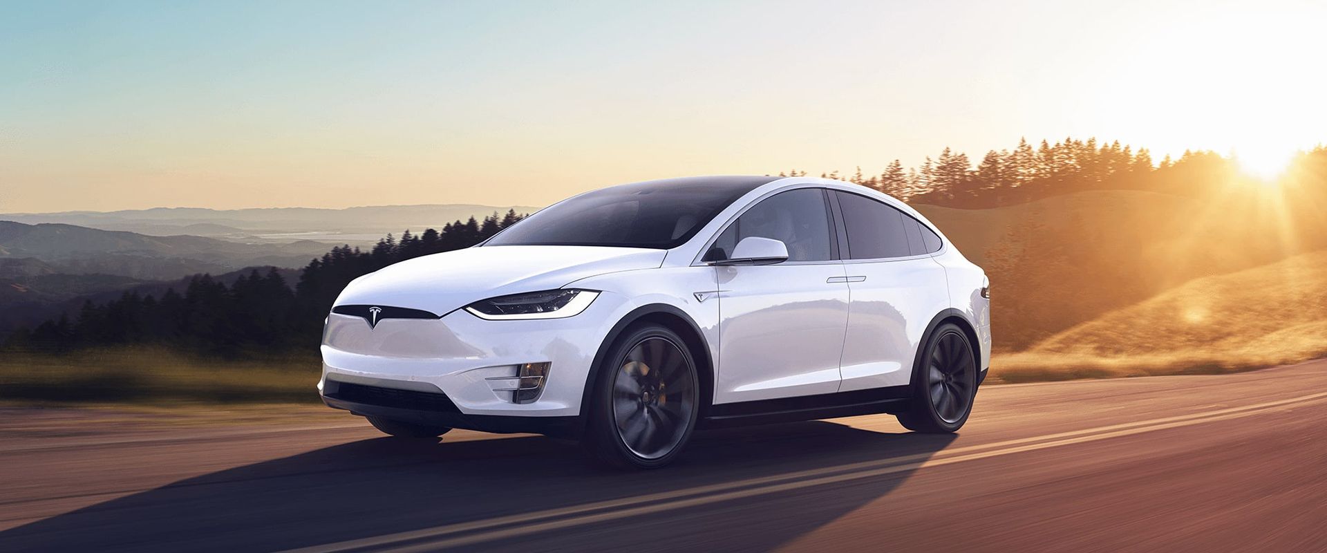 نمای کناری خودروی Tesla Model X به رنگ سفید در جاده