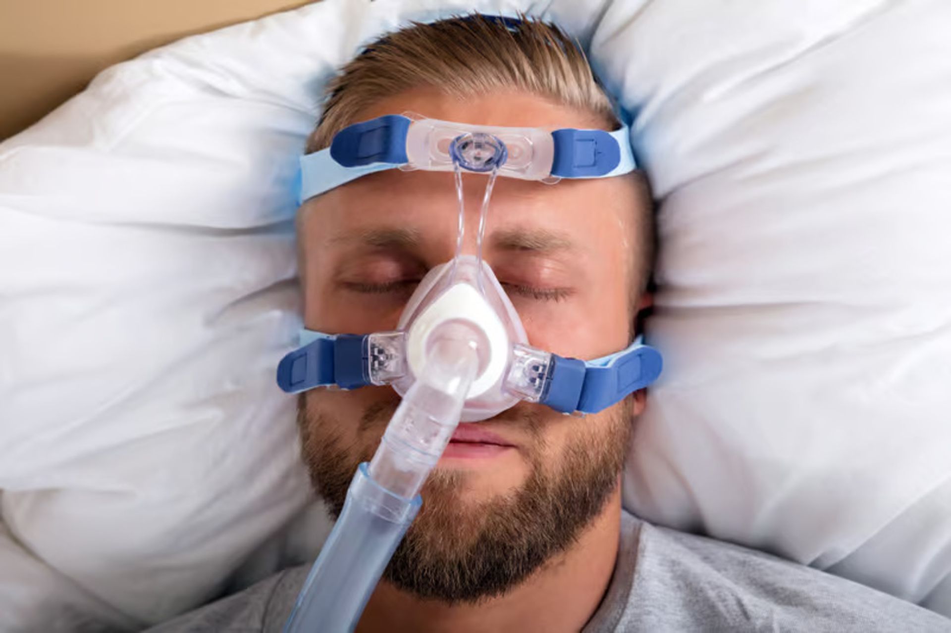مرد جوان درحالی‌که خواب است از دستگاه CPAP استفاده می‌کند