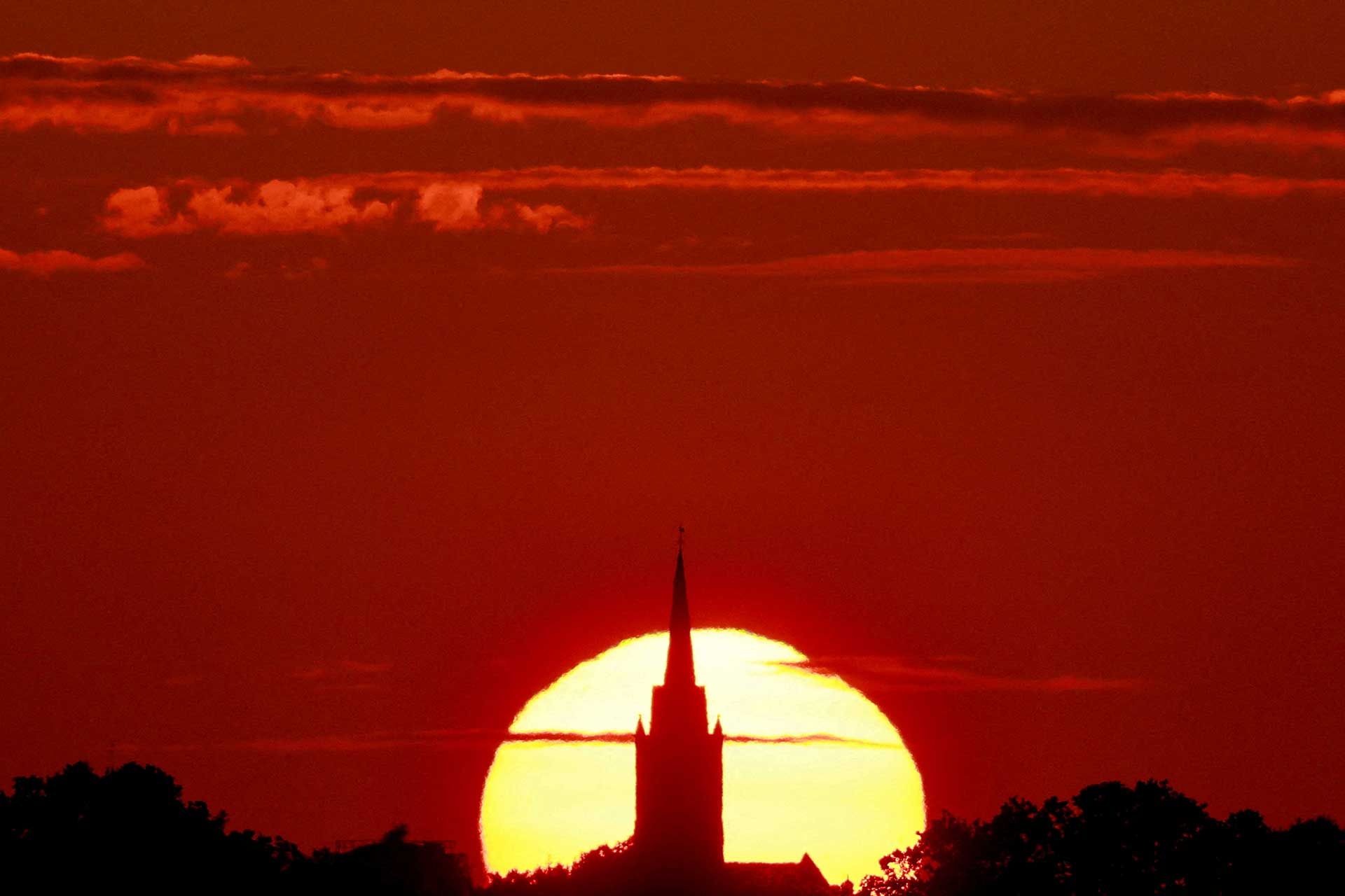 خورشید در پشت کلیسایی در سنکورت فرانسه در ژوئیه ۲۰۲۳