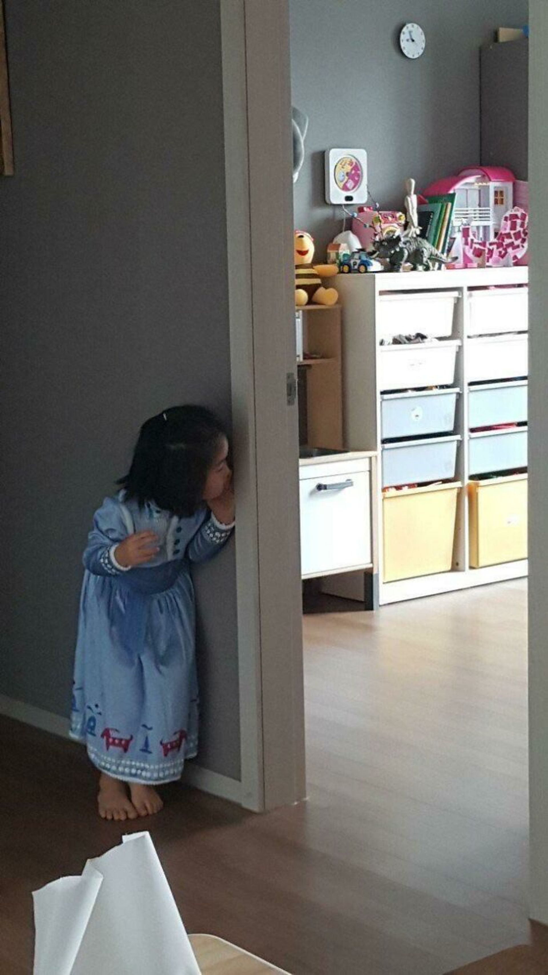 دختربچه در حال پاییدن عروسک‌هایش در اتاق