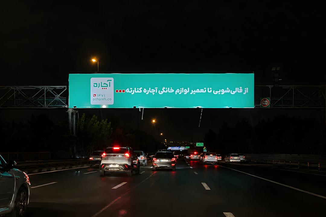 بیلبورد بزرگ تبلیغات آچاره (Achareh) در شب بالای بزرگراه