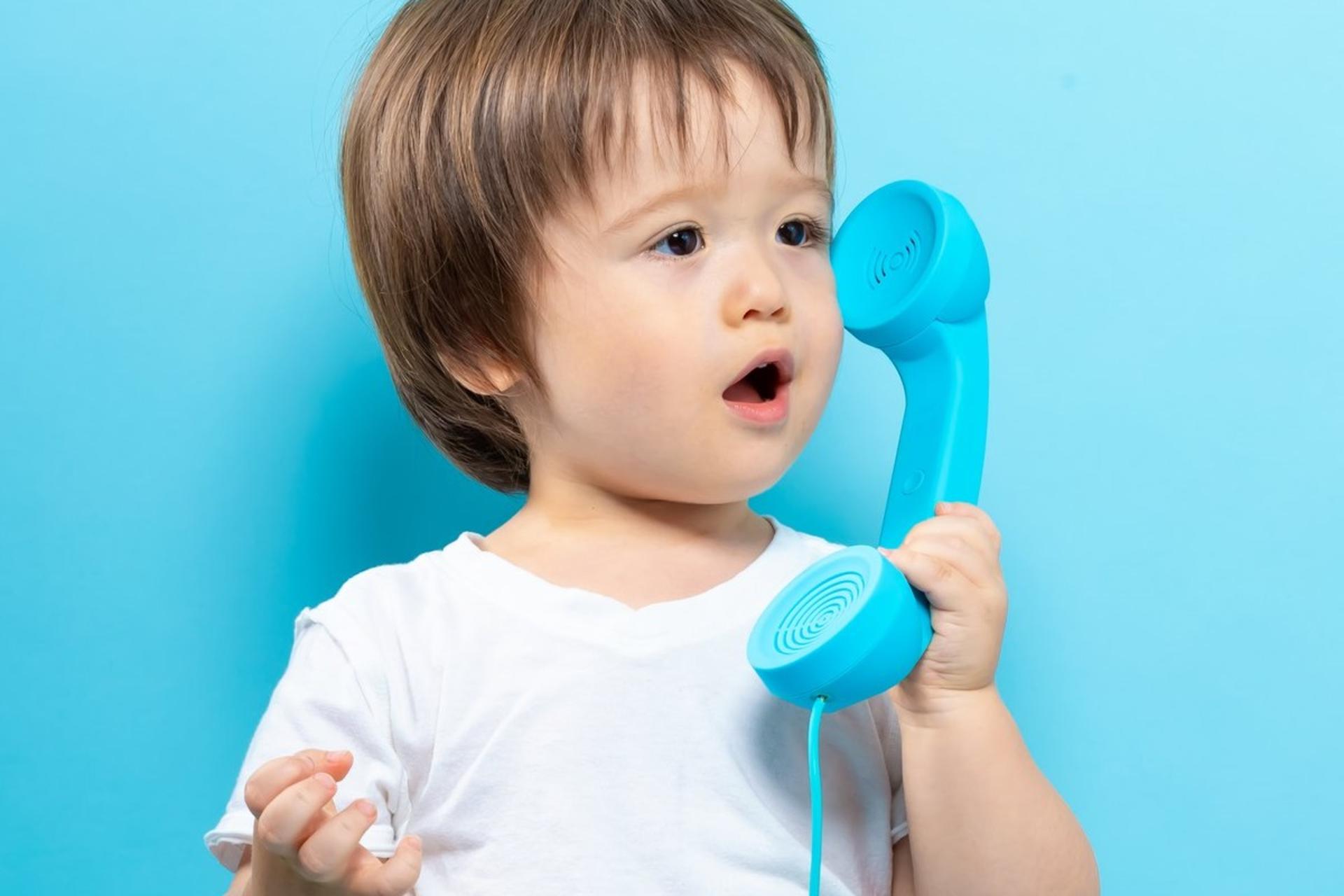 کودکی درحال صحبت‌کردن با گوشی تلفن است