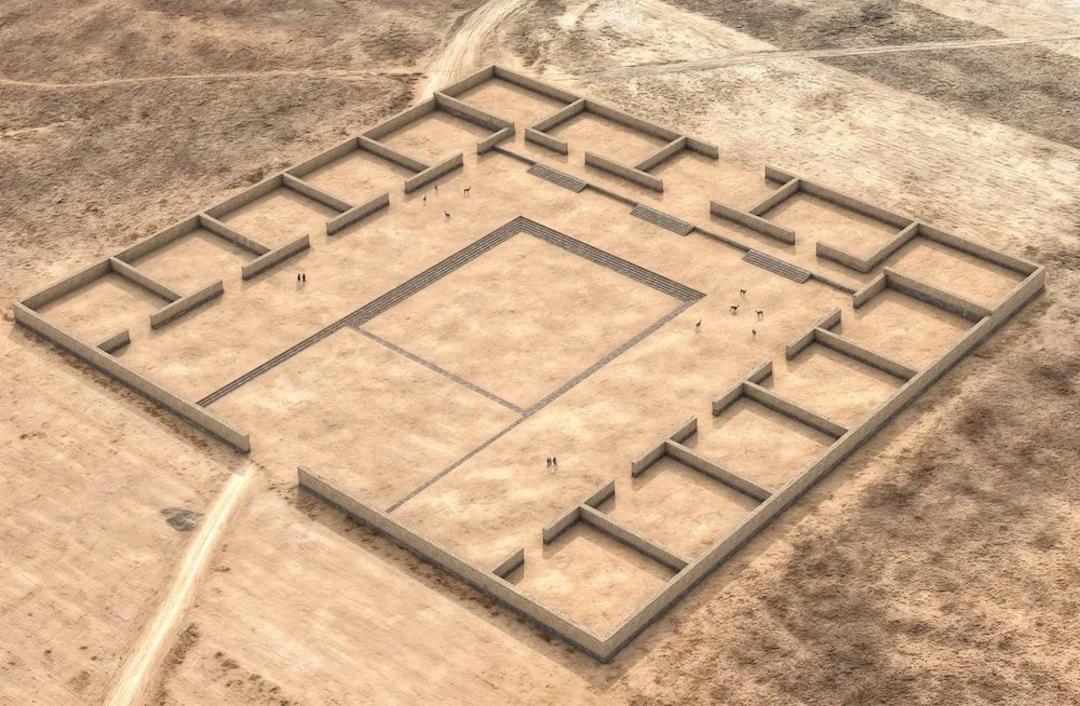 نمای هوایی از بازسازی یک مجموعه بنای باستانی با دیوارهای سنگی و حیاط مرکزی بزرگ در محیط بیابانی.