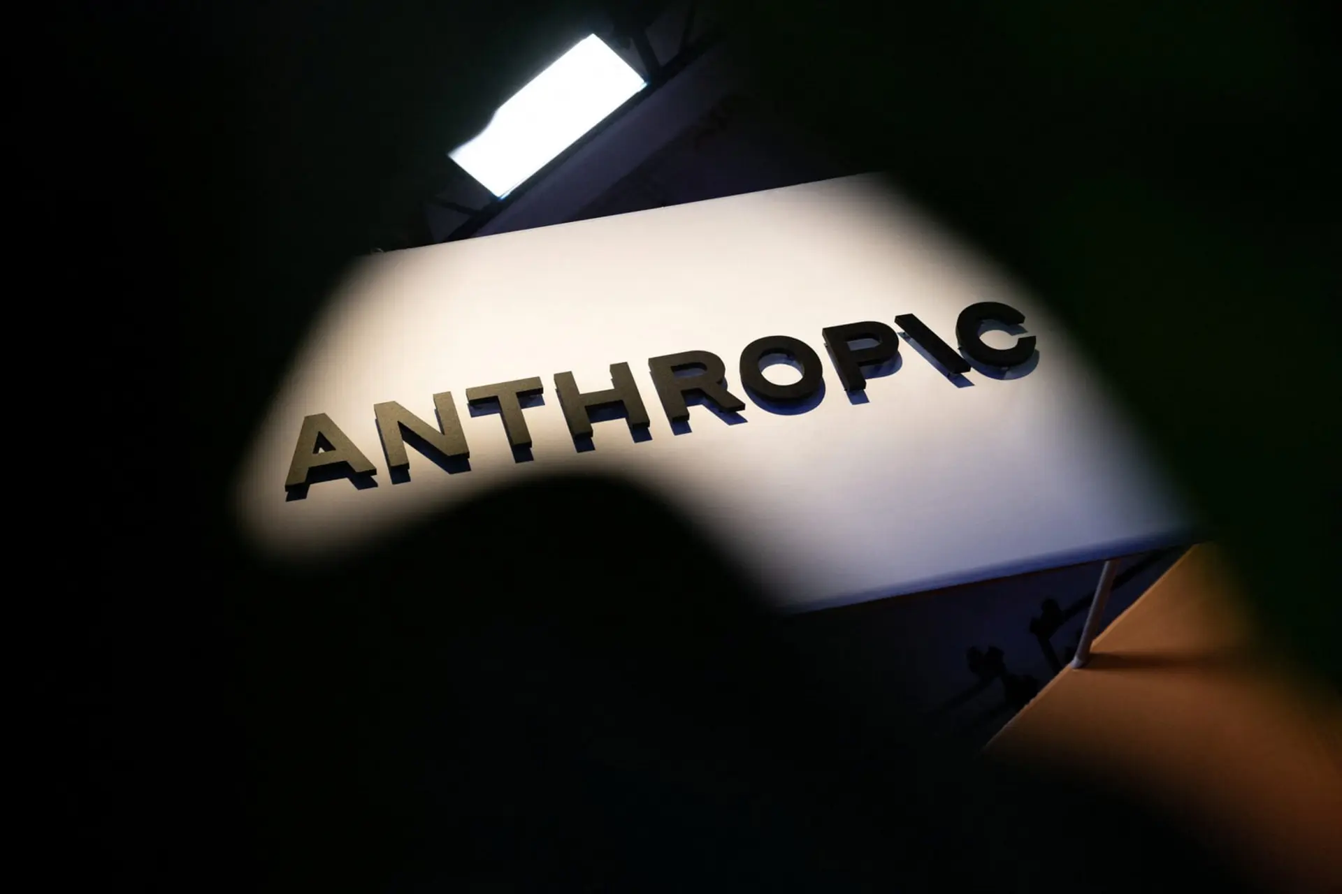 لوگوی شرکت آنتروپیک (Anthropic) روی یک تابلوی سفید در محیطی با نورپردازی متمرکز