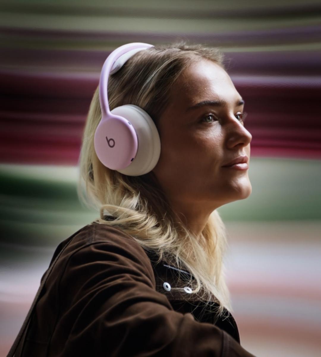 هدفون بیتس ۳۶۰ (Beats 360) با بالشتک‌های صورتی روی سر یک زن