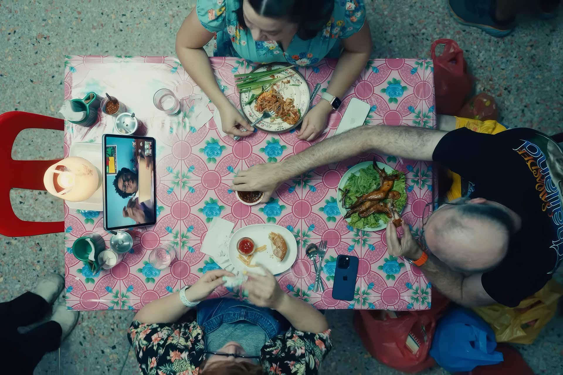 صحنه‌ای از تبلیغ جدید اپل که چند نفر را دور میز درحال غذا خوردن و استفاده از آیپد نشان می‌دهد