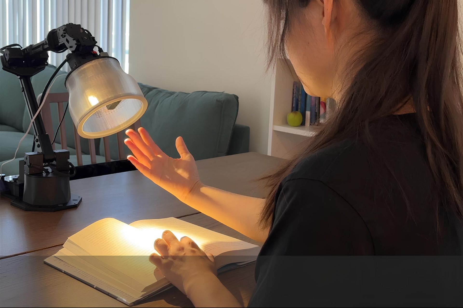 دختر با دست خود به یک چراغ مطالعه اشاره میکند